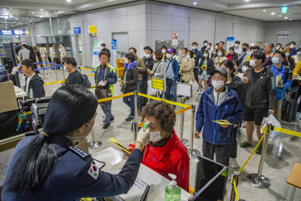 설 연휴 기간인 26일 오전 중국 하이난에서 무안공항을 통해 국내로 들어오는 입국자들을 상대로 보건당국이 입국 전 검역장 앞에서 개별 체온을 측정하고 있다. /김진수 기자 jeans@kwangju.co.kr