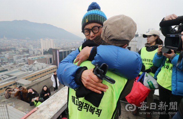 지난해 12월 영남대의료원 건물 옥상에서 고공농성 중인 해고노동자를 응원하기 위해 부산에서 대구까지 100km를 도보 행진한 김진숙 민주노총 부산본부 지도위원(왼쪽)이 농성 중인 박문진 씨를 찾아 부둥켜 울고 있다. 매일신문 DB