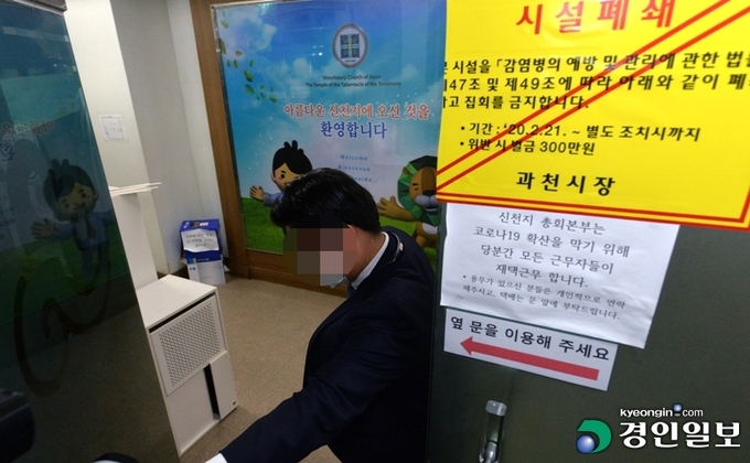 중앙재난안전대책본부가 신천지본부에 대한 행정조사에 들어간 5일 오전 신천지예수교회 관계자가 입구를 폐쇄하고 있다. /김도우기자 pizza@kyeongin.com