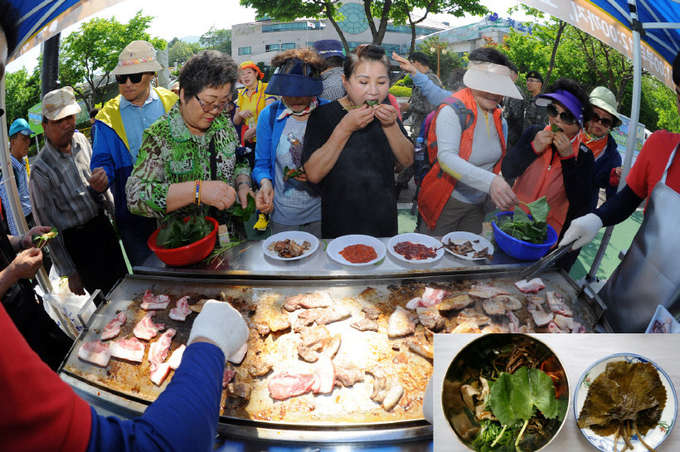 곰취축제에서 흑돼지 곰취쌈을 먹고있는 관광객들과 곰취비빔밥·장아찌. /양구군 제공