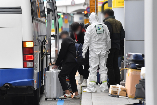 신종코로나바이러스 감염증(코로나19)이 확산되고 있는 가운데 지난달 26일 김해공항 국제선 청사 입구에서 방진복을 입은 관계자의 안내에 따라중국인 유학생들이 차량에 짐을 싣고 있다./ 경남신문 DB/