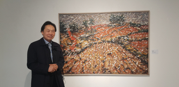 김상윤 고문이 1994년 자신의 두번째 소장작이 된 송필용 작가의 ‘땅의 역사-남녘의 땅’ 앞에서 포즈를 취했다.