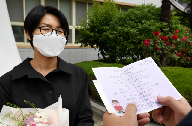 스승의 날을 하루 앞둔 14일 오전 한 학생이 창원의 중학교로 전근을 간 선생님을 찾아 꽃다발과 도시락을 전달 후 손편지를 읽고 있다./성승건 기자/