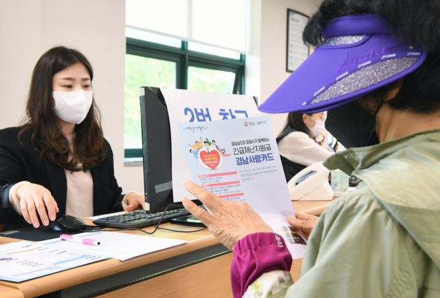 창원 용지동 행정복지센터를 찾은 경남도 긴급재난지원금 신청자가 경남사랑카드 안내문을 보고 있다./김승권 기자/