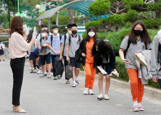 고등학교 1학년·중학교 2학년·초등학교 3∼4학년을 대상으로 한 3차 등교 개학일인 3일 오전 대전시 서구 탄방중학교에서 선생님이 등교하는 학생들에게 인사하고 있다. 윤종운 기자