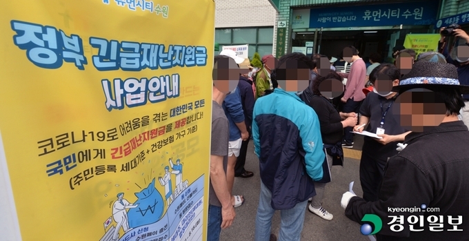 정부재난지원금 현장신청 첫날인 지난달 18일 수원 세류3동 행정복지센터 앞이 붐비고 있다. /김도우기자 pizza@kyeongin.com