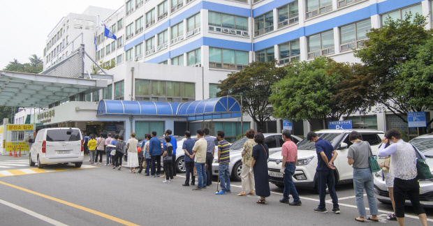 2일 오전 광주시 동구 조선대병원에 입원 중인 환자가 코로나19 확진 판정을 받아 환자가 입원해 있던 52병동이 임시 폐쇄된 가운데 이날 오전 병원을 찾은 시민들이 출입구에 설치된 문진소로 들어가기 위해 줄지어 서 있다. /김진수 기자 jeans@kwangju.co.kr