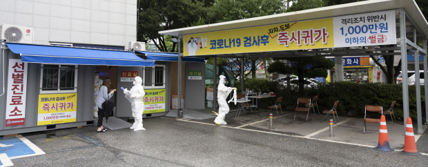 코로나19 확산세가 주춤해진 15일 오전 광주 동구청 주차장에 마련된 코로나19 선별진료소에서 의료진들이 방호복을 점검하고 있다. /최현배 기자choi@kwangju.co.kr