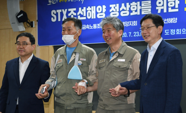23일 오후 경남도청 도정회의실에서 열린 ‘STX조선해양 정상화를 위한 노사정 협약식’에서 허성무(왼쪽부터) 창원시장, 이장섭 STX조선노조지회장, 장윤근 STX조선해양 대표이사, 김경수 도지사가 손을 맞잡고 기념촬영을 하고 있다./김승권 기자/