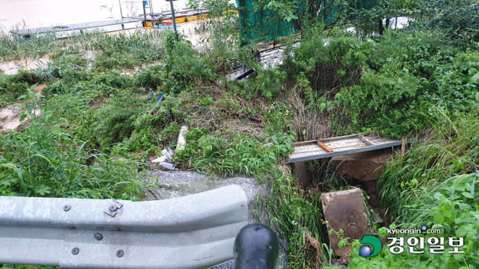 3일 오후1시42분께 본죽저수지 붕괴소식에 확인한 현장. 저수지 우측 도로변에서 합류하는 우수가 콘크리트 배수지로 합류하지못해 물 웅덩이가 생기며 도로를 가로질러 누수현상을 보이고 있다. 이천/서인범기자 sib@kyeongin.com