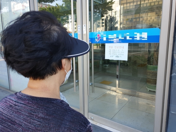 14일 제주시 삼도1동 한 내과를 찾은 임모씨가 병원 문을 닫은 것을 보고 허탈해 하고 있다.
