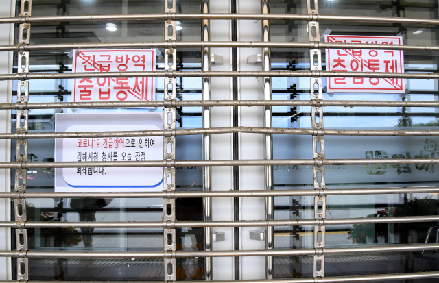 코로나19 확진자가 김해시청을 다녀간 사실이 확인된 26일 오후 김해시청 출입문에 청사 잠정 폐쇄 안내문이 붙어 있다./성승건 기자