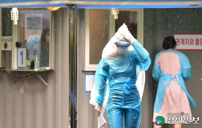 코로나19 확산세가 계속되고 있는 27일 오후 인천 계양구 보건소 선별진료소에서 의료진이 비가 내리는 가운데 분주히 움직이고 있다. /조재현기자 jhc@kyeongin.com