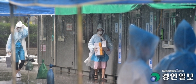 코로나19 확산세가 계속되고 있는 27일 오후 인천 계양구 보건소 선별진료소에서 의료진이 비가 내리는 가운데 분주히 움직이고 있다. /조재현기자 jhc@kyeongin.com
