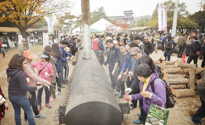 여주시는 코로나19 확산 방지를 위해 오는 15∼18일 예정된 '여주오곡나루축제'를 취소했다. 사진은 지난해 축제장에 설치된 50m 대형 군고구마통에 수천명의 인파가 참여, 군고구마 기네스 퍼포먼스를 펼치는 모습이다. 2020.10.7 /여주시 제공