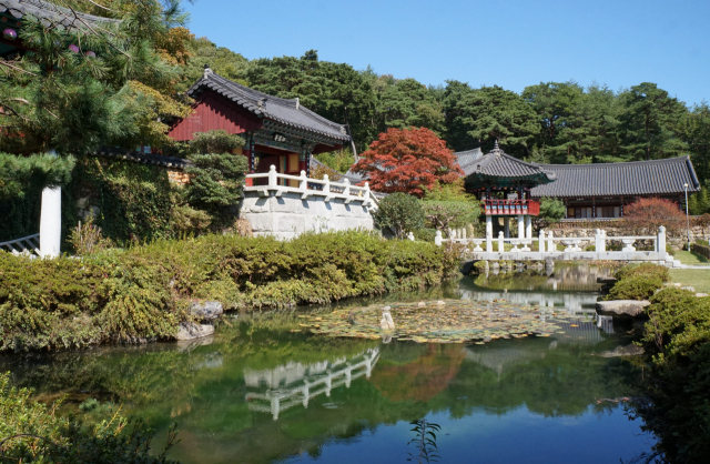푸른 산으로 둘러싸인 사명암과 파란 하늘을 담은 인공연못이 한 폭의 그림 같은 풍경을 연출하고 있다.