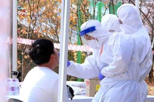 인제군이 15일 북면에 있는 한 아파트 주차장에서 선별진료소를 설치, 운영하고 있는 가운데 의료진이 주민에게서 검체를 채취하고 있다.
