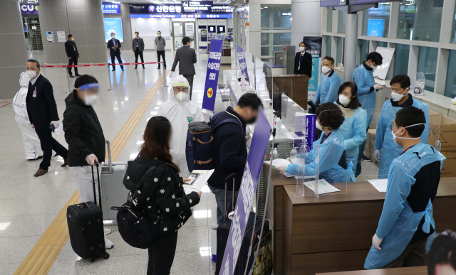 10일 오후 김해국제공항 국제선 대합실에서 부산~칭다오 노선 입국자들이 김해공항수송지원센터의 안내를 받고 있다. 강선배 기자 ksun@