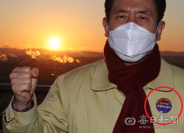 2021년 1월1일 이강덕 경북 포항시장이 호미곶에서 일출을 뒤로 화이팅을 외치고 있다. 왼쪽 원내에 '포항주소갖기' 배지를 달았다. 포항시 제공