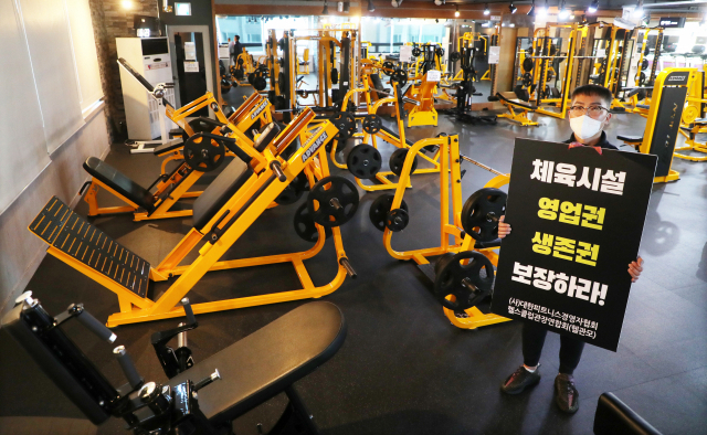 4일 오후 부산시 남구의 한 피트니스센터에서 한 업주가 피켓을 들고 ‘생존권 보장’을 요구하며 1인 시위를 하고 있다. 강선배 기자 ksun@