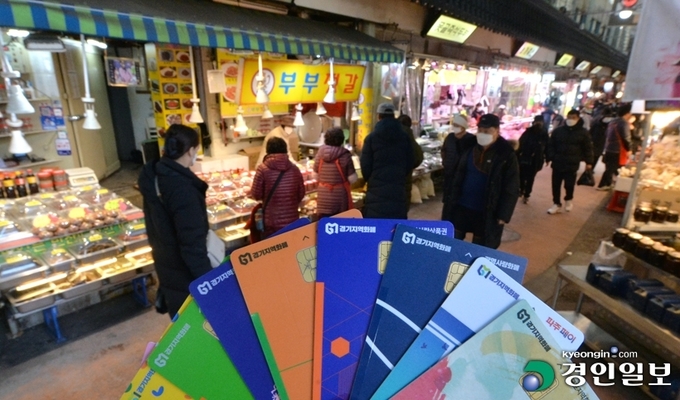 수원시 못골시장을 찾은 시민들이 물건을 구매하고 있다. 사진 하단은 재난기본소득 지급 수단 중 하나인 경기지역화폐. 2021.1.20 /김도우기자 pizza@kyeongin.com