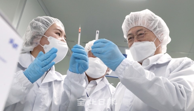 문재인 대통령은 18일 코로나19 백신접종용 최소잔여형(LDS) 백신주사기 생산 업체인 군산의 (주)풍림파마텍을 방문해 생산라인을 둘러보고 LDS 백신주사기를 살펴보고 있다. /오세림 기자