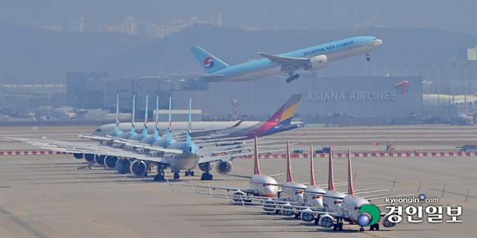 24일 오전 인천국제공항 계류장에 운항을 멈춘 항공기들 사이로 화물기가 이륙하고 있다. 코로나19의 전 세계 대유행으로 전 세계 공항 이용객이 급감하면서 인천공항도 직격탄을 맞았다. 하지만 인천공항공사는 위기를 기회로 삼아 공항 방역 성과를 해외에 전수하고 제2여객터미널 확장 등을 포함하는 4단계 사업을 차질 없이 진행해 포스트 코로나에 대비하고 있다. 2021.3.24 /조재현기자 jhc@kyeongin.com