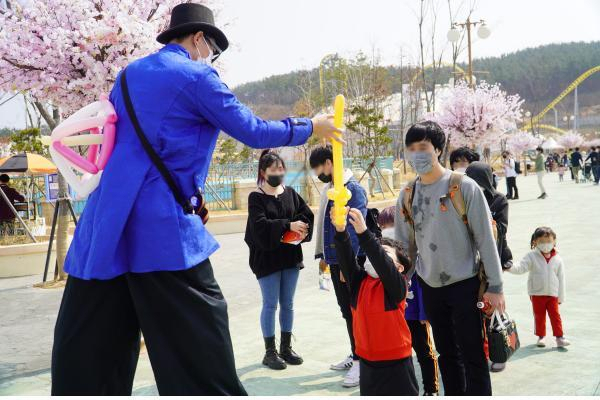 키다리 삐에로가 로봇랜드를 찾은 어린이들에게 풍선을 나눠주고 있다.