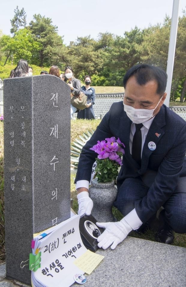 5일 오전 광주 북구 국립 5·18 민주묘지에서 고(故) 전재수 군의 형 재룡씨가 묘비를 어루만지고 있다. 5·18 당시 초등학교 4학년이었던 전 군은 계엄군이 쏜 총에 맞아 숨졌다. 제대로 된 사진 한장 남기지 못해 묘비 사진을 무궁화로 대체했다가 41년만에 유족이 사진을 발견하면서 이날 묘비 제막식 및 추모식을 열었다./최현배 기자choi@kwangju.co.kr
