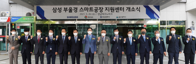 26일 오후 경남테크노파크에서 부울경 스마트 공장 지원센터 개소식이 열렸다. 김승철(왼쪽부터) 경남테크노파크원장 직무대행, 이상창 경남지방중기청장, 박준호 도의회경제환경위원회위원장, 안승대 울산시 기획조정실장, 김윤일 부산 경제부시장, 김경수 경남도지사, 고동진 삼성전자 대표이사, 김종호 삼성전자 사장, 주은기 삼성전자 부사장, 유동욱 한국전기연구원 원장 직무대행, 이동찬 한국산업단지공단 경남본부장, 구영모 한국자동차연구원 본부장이 현판식 후 기념촬영을 하고 있다./성승건 기자/