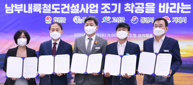 최용남(왼쪽부터) 합천군 부군수, 정준석 진주시 부시장, 백두현 고성군수, 변광용 거제시장, 강석주 통영시장이 2일 경남도청 프레스센터에서 남부내륙철도 건설사업 조기 착공을 바라는 공동건의문을 들어 보이고 있다./김승권 기자/