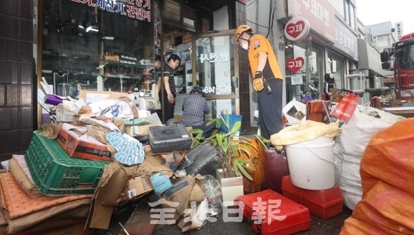 밤사이 많은 양의 비가 내린 6일 익산시 창인동의 한 상가에서 상인들이 복구 작업을 하고 있다. /사진 = 조현욱 기자