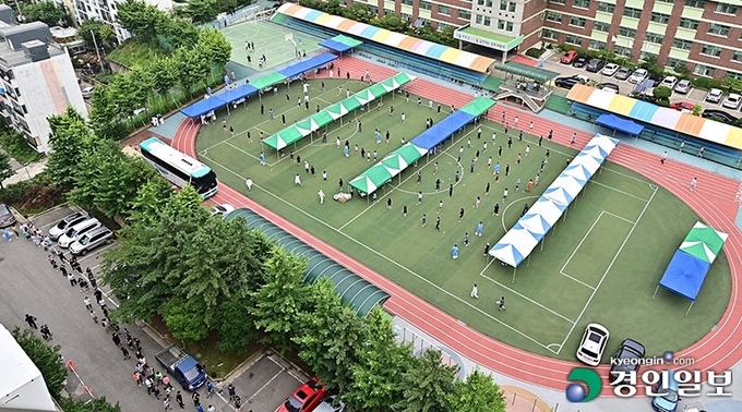 인천의 한 초등학교에서 코로나 19 집단감염이 발생한 6일 오전 인천시 미추홀구 인주초등학교에 설치된 선별진료소를 찾은 학생과 학부모들이 검사 순서를 기다리고 있다. 2021.7.6 /조재현기자 jhc@kyeongin.com