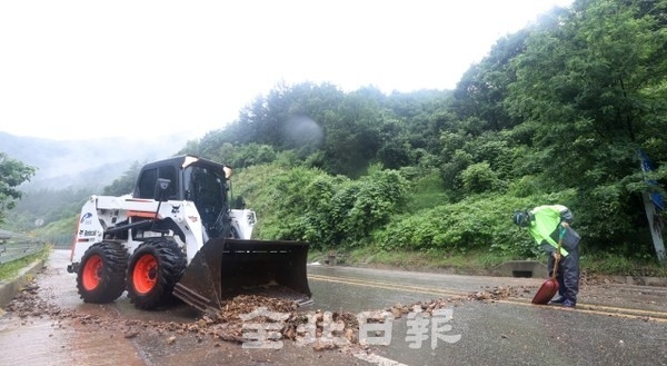 7일 진안군 동향면 성산리 진성로 일대에 폭우로 토사가 흘러내려 진안군 관계자들이 보수작업을 하고 있다. / 사진 = 조현욱 기자