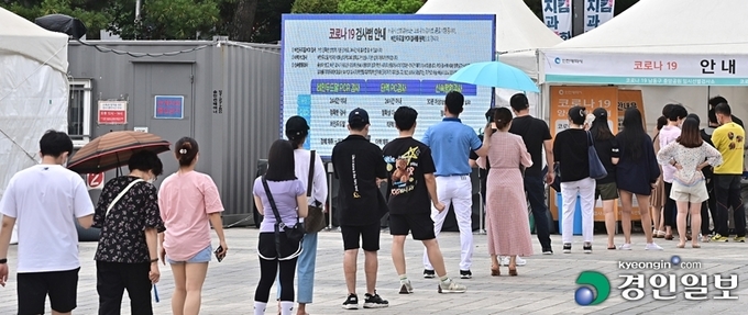 코로나19 신규 확진자가 7백명대에서 하루새 1천2백 명대로 폭증한 7일 오후 인천시 남동구 구월동 중앙공원 임시선별검사소를 찾은 시민들이 검사를 받기 위해 긴 줄을 서 있다. /조재현기자 jhc@kyeongin.com
