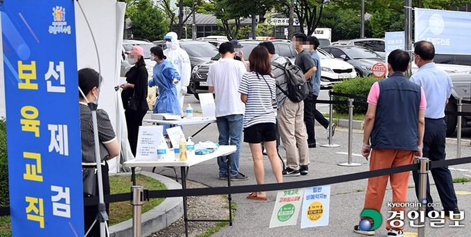 코로나 19 신규 확진자가 1,212명을 기록한 7일 오전 수원시 권선구보건소에 설치된 선별검사소를 찾은 시민들이 검사를 받기 위해 긴 줄을 서 있다.2021.7.7 /임열수기자 pplys@kyeongin.com