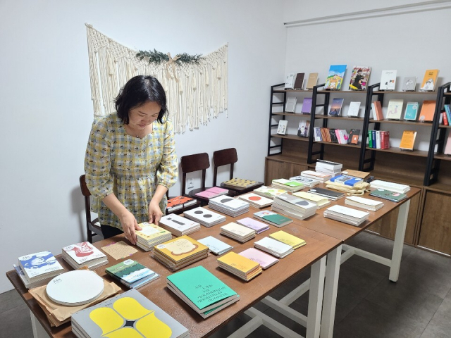 주선경 대표가 독립출판물 서가에서 책을 정리하고 있다.