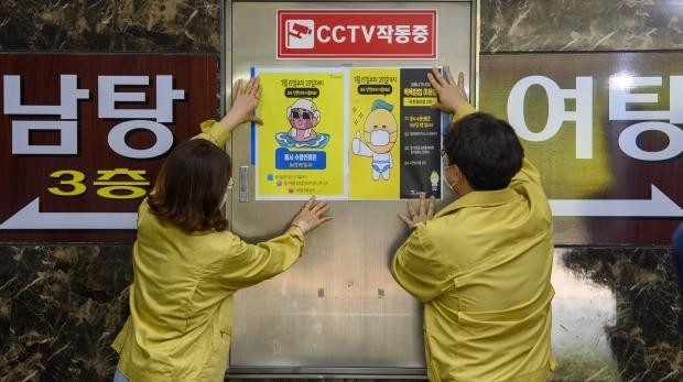 15일부터 사회적 거리두기가 2단계로 격상됨에 따라 14일 오후 광주 북구청 보건위생과 공중위생팀 직원들이 관내 한 목욕장에서 강화된 수칙 안내문을 붙이고 있다. /김진수 기자 jeans@kwangju.co.kr