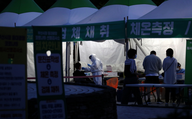 전국 코로나19 확진자 수가 연일 1000명대를 기록하는 가운데 13일부터 부산시청 등대광장 임시선별검사소와 부산역 임시선별검사소가 운영시간을 오후 9시까지로 연장해 야간운영에 들어갔다. 부산시청 임시선별검사소에서 시민들이 검사를 받고 있다. 김경현 기자 view@
