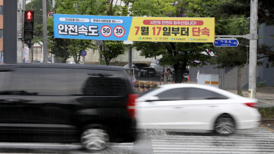 15일 오후 대구 동구 파티마삼거리에 걸린 안전속도 5030 단속 예고 현수막 아래로 시민들이 횡단보도를 건너고 있다. 김영진 기자 kyjmaeil@imaeil.com