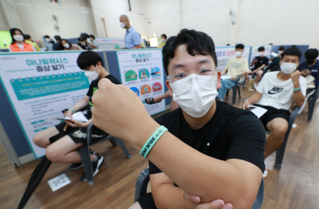 고교 3학년 학생과 교직원에 대한 코로나19 백신 접종이 시작된 19일 오전 부산 부산진구 예방접종센터에서 접종을 받은 학생들이 접종 확인 팔찌를 들어보이고 있다. 김경현 기자 view@