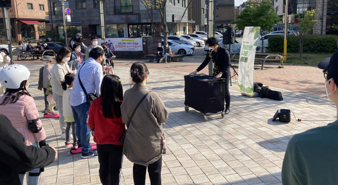 수원 시민들이 '거리로 나온 예술' 프로그램으로 신동카페거리 일원에서 진행된 마술공연 버스킹을 지켜보고 있다. /수원시 제공