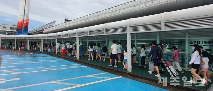제주국제공항에 도착한 관광객들이 렌터카하우스로 이동하고 있다.