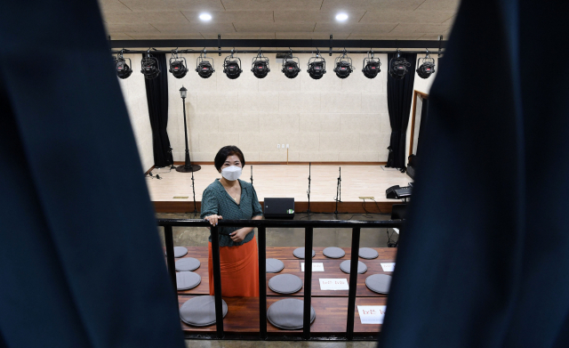 김해 봉리단길 봉황예술극장에서 곽지수 대표가 무대 입구 커튼 사이로 포즈를 취하고 있다.