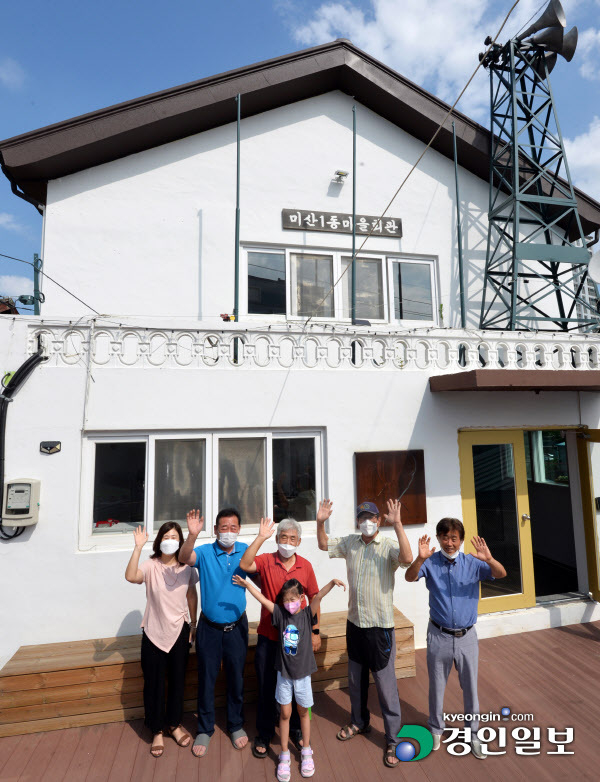 10일 시흥시 미산동 주민들이 직접 짓고 리모델링한 마을회관 앞에 모여 손을 흔들고 있다. 이곳 주민들은 지역 활동가들과 시흥시, 경기문화재단과 협력해 낙후된 마을과 지역 문화를 되살리기 위한 활동을 하고 있다. 2021.8.10 /김금보기자 artomate@kyeongin.com