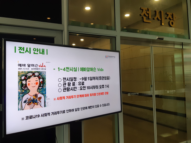 지난 10일 오후 창원 성산아트홀 내 전시장 입구에 코로나 확산으로 인한 인원 제한을 알리는 안내 영상이 설치돼 있다.