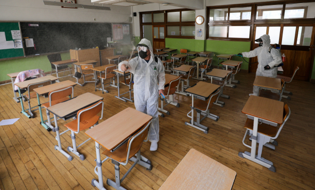 2학기 개학을 앞둔 12일 대구 수성구 동도중학교 교실에서 대구학교안전공제회 관계자들이 방역 작업을 하고 있다. 김영진 기자 kyjmaeil@imaeil.com