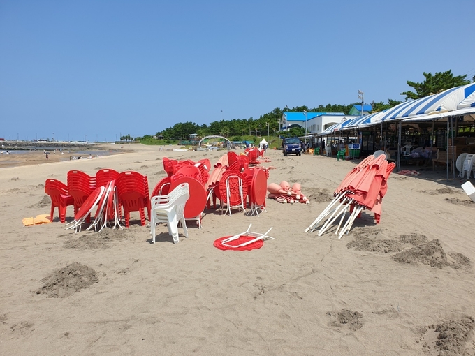 제주형 사회적 거리두기 4단계 시행 첫날인 18일 폐장된 제주시 이호테우해수욕장에서 계절음식점 관계자들이 테이블과 식기를 치우고, 파라솔과 의자들을 철거하고 있다.