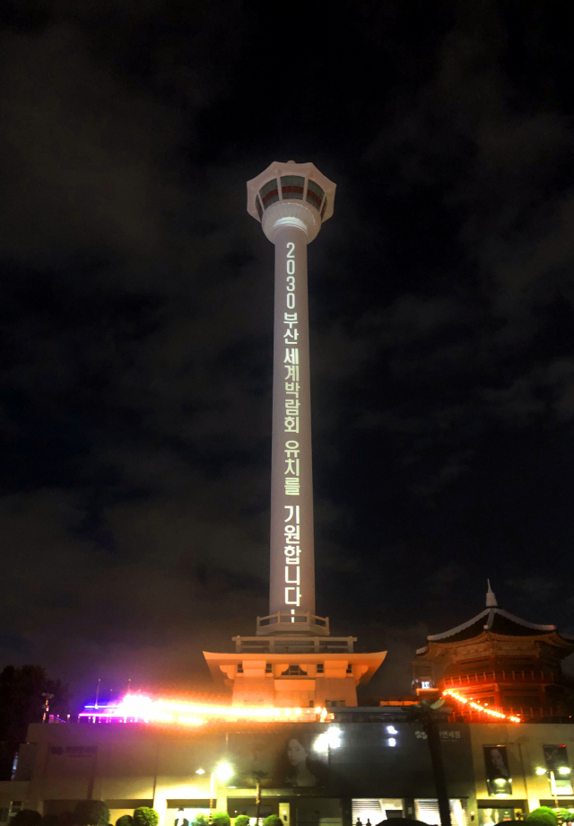 부산 중구 용두산공원 부산타워에 2030부산세계박람회 유치를 염원하는 메시지가 송출되고 있다. 24일 부산시는 광안대교와 황령산 전망쉼터 등 부산의 랜드마크 3곳에 매일 오후 8시 30분부터 10분간 박람회 유치 염원 메시지를 송출한다고 밝혔다. 부산시 제공