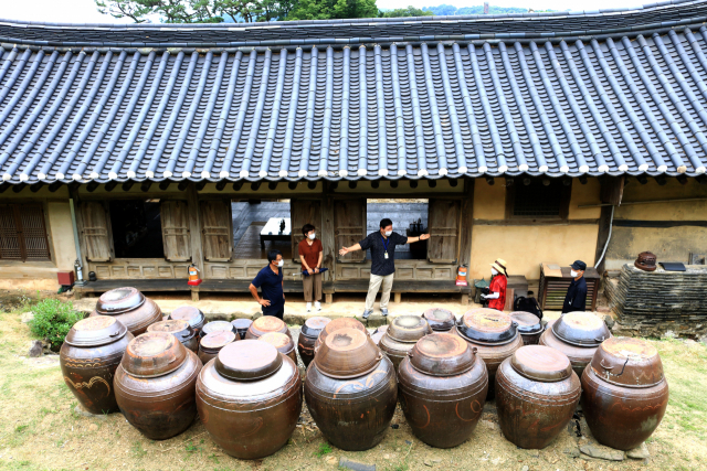 장독대가 있는 뒤란 풍경, 문화관광해설사가 관광객들을 대상으로 해설을 하고 있다.